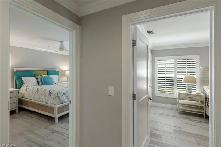 Bedroom featuring ceiling fan, ornamental molding, and light wood-type flooring