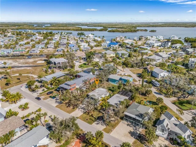 Aerial view of property and surrounding area featuring nearby suburban area and a large body of water