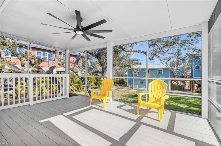 Sunroom / solarium featuring a ceiling fan and a deck