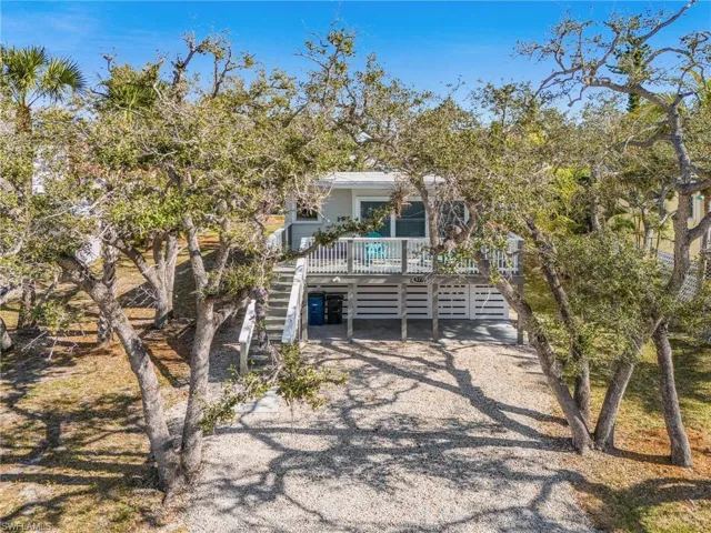 View of front facade with a carport, driveway, stairs, and a deck
