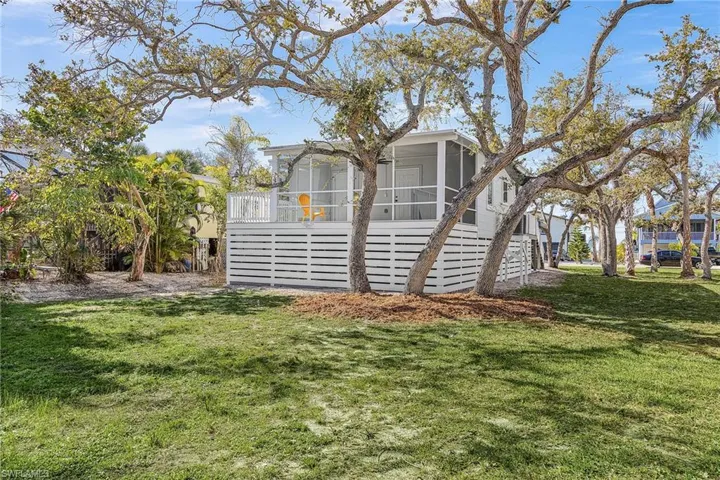 View of side of property with a sunroom and a yard