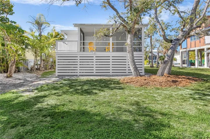 View of front of home with a sunroom and a front lawn