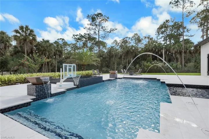 Outdoor pool featuring a patio and view of scattered trees