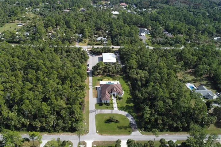 Aerial view of property and surrounding area featuring a heavily wooded area