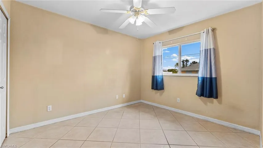 Bedroom featuring light tile patterned floors and ceiling fan