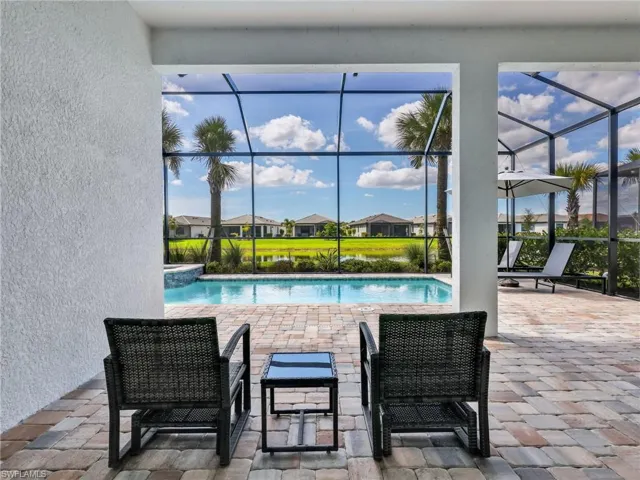 Screened lanai with a paver patio and inground swimming pool