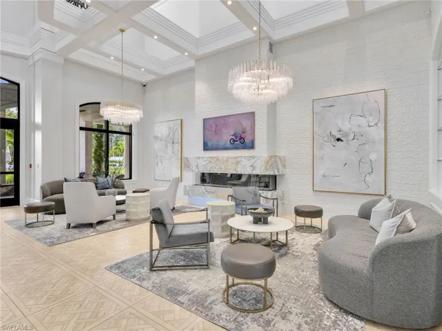Clubhouse Sitting Area with High ceilings, decorative beams, patterned tile flooring, and a built-in fireplace with a stone surround