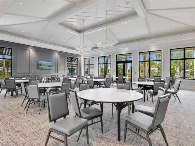Clubhouse Spacious gathering room featuring a coffered ceiling, multiple large windows, and contemporary light fixtures