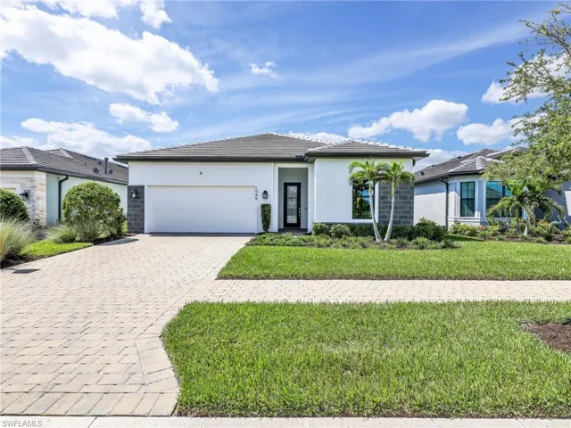 Contemporary stucco exterior with dark gray accents, a dark roof, paver driveway, and an attached two-car garage