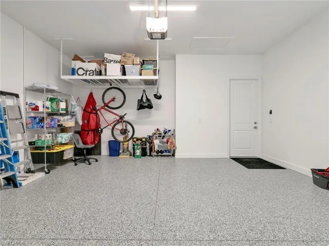 Garage with epoxy flooring, white walls, and an overhead storage rack
