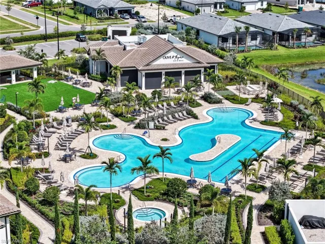 Amenity Center Expansive aquatic center featuring a large swimming pool, separate spa, and surrounding hardscaping