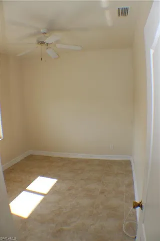 Unfurnished room featuring ceiling fan and light tile patterned floors
