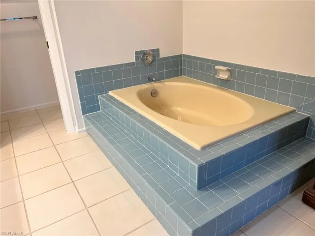 Bathroom with tile patterned floors and a relaxing tiled tub