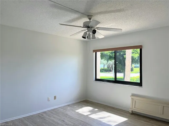 Unfurnished room with light hardwood / wood-style floors, a textured ceiling, and ceiling fan