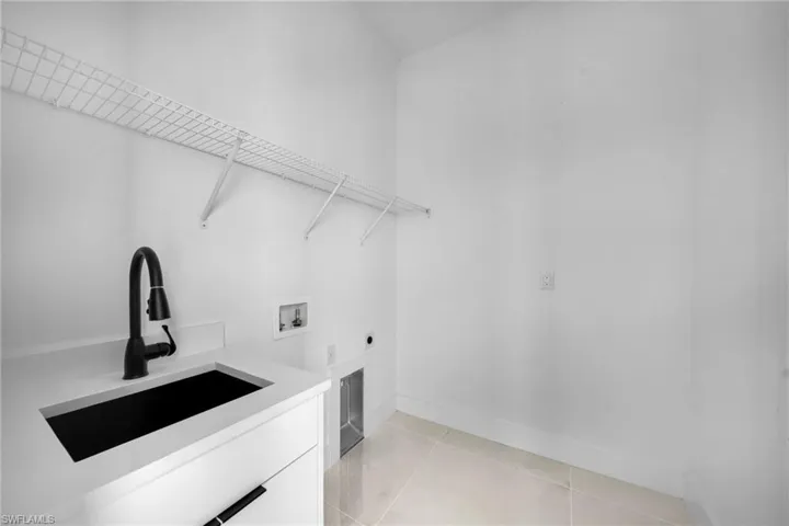Laundry room with light tile patterned floors, washer hookup, and electric dryer hookup