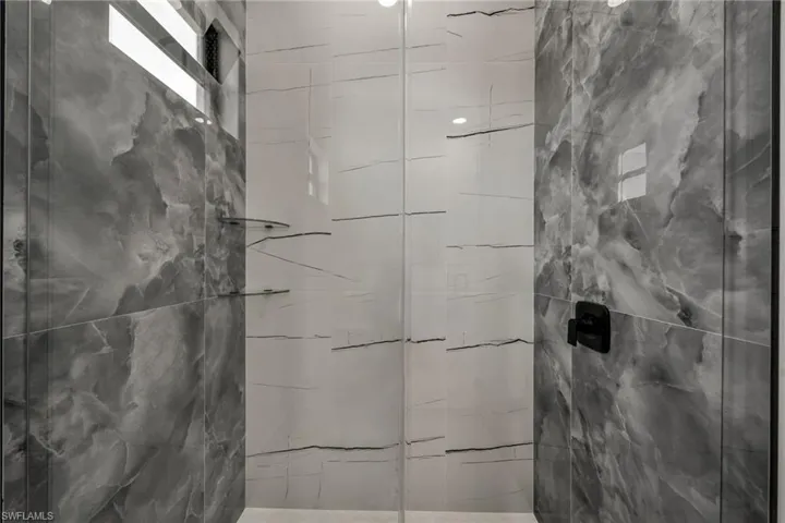 Full bath featuring a marble finish shower