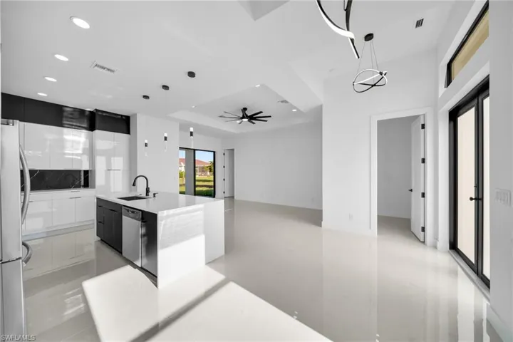 Kitchen featuring modern cabinets, hanging light fixtures, dark cabinetry, stainless steel appliances, and recessed lighting