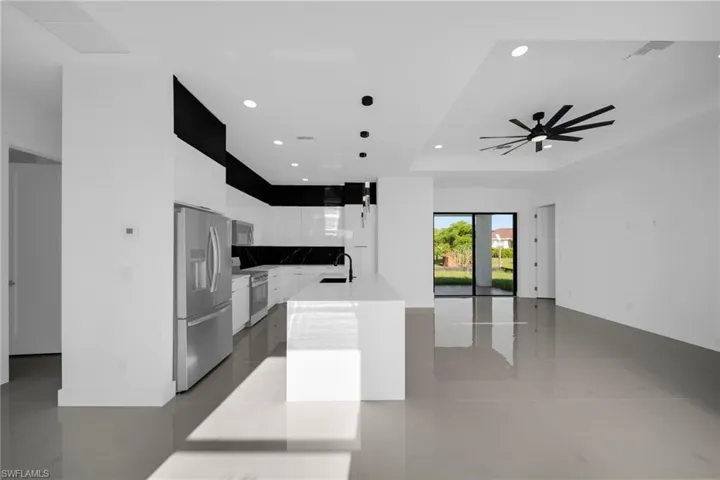 Kitchen featuring modern cabinets, appliances with stainless steel finishes, light tile patterned floors, white cabinetry, and recessed lighting