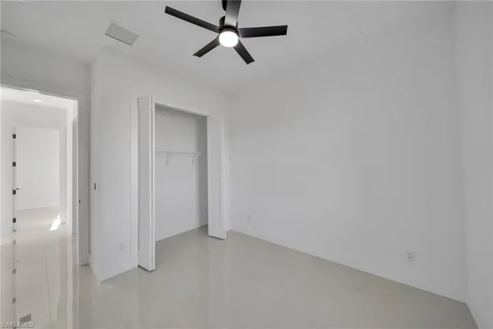 Unfurnished bedroom featuring a ceiling fan and a closet