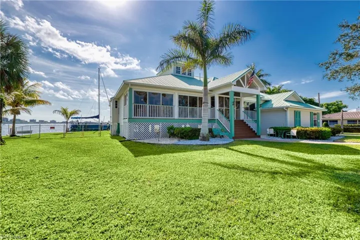 Bungalow-style home with a metal roof, stairway, and covered porch