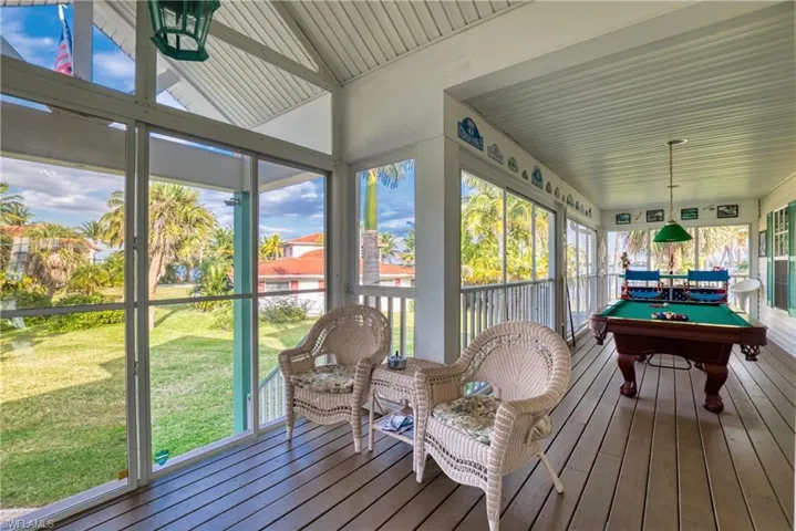 Sunroom with healthy amount of natural light, wood-type flooring, billiards table, and lofted ceiling