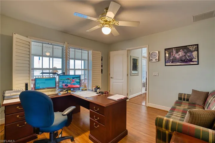 Office space with light wood-type flooring and a ceiling fan