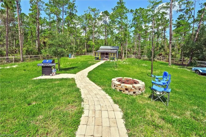 Expansive green lawn with a paved pathway leading towards a structure