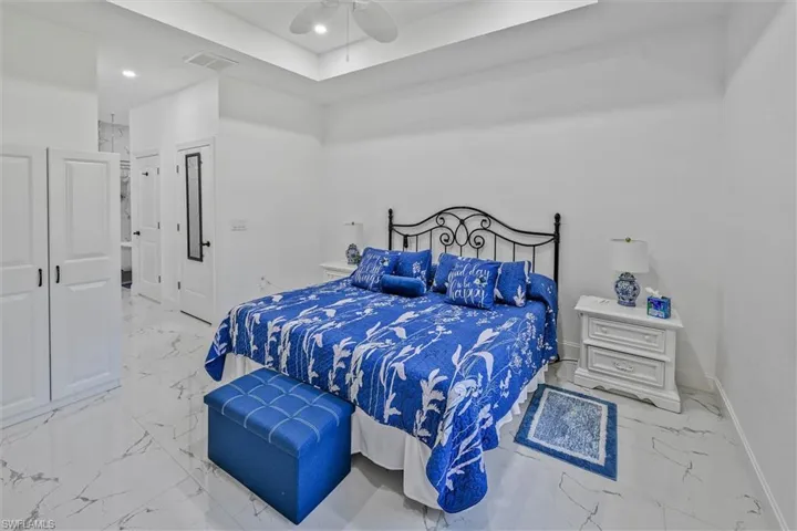 Spacious room featuring white walls and marble-look tile flooring