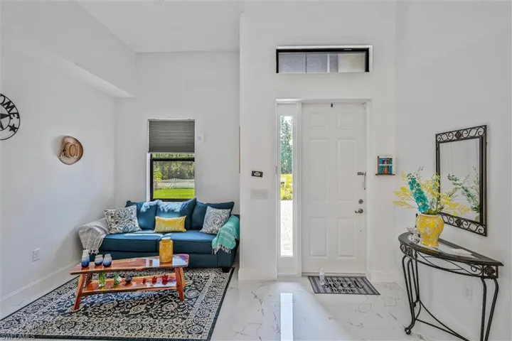Entryway featuring a paneled door with a sidelight, transom window, and high ceilings
