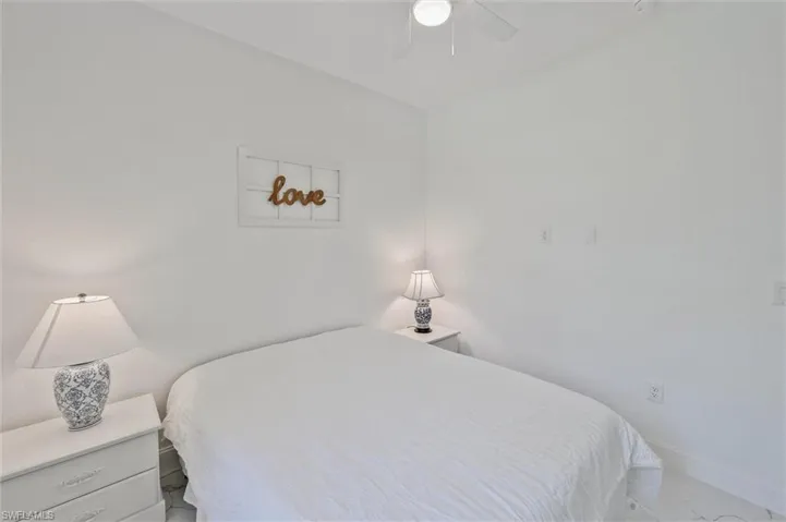Bright bedroom featuring neutral wall tones, a ceiling fan, and white-finish flooring