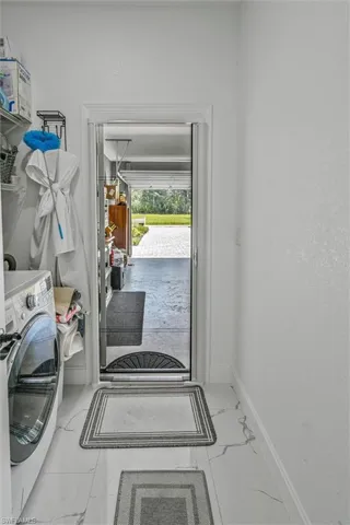 Utility area with white walls and a white-and-gray patterned floor
