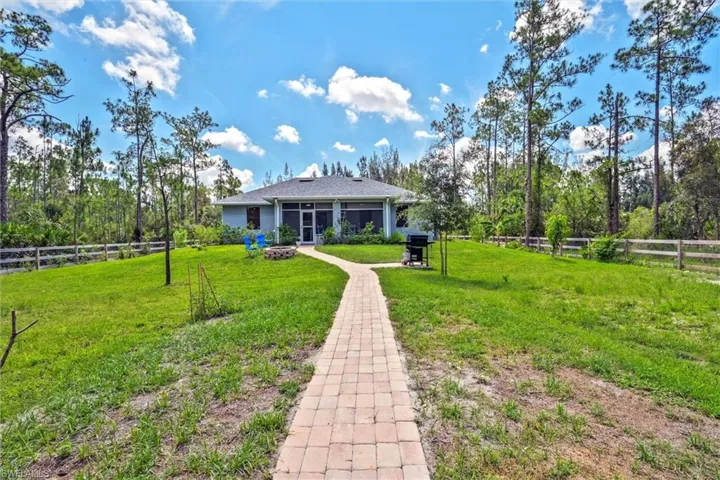 Expansive green lawn with a paver walkway leading to the residence