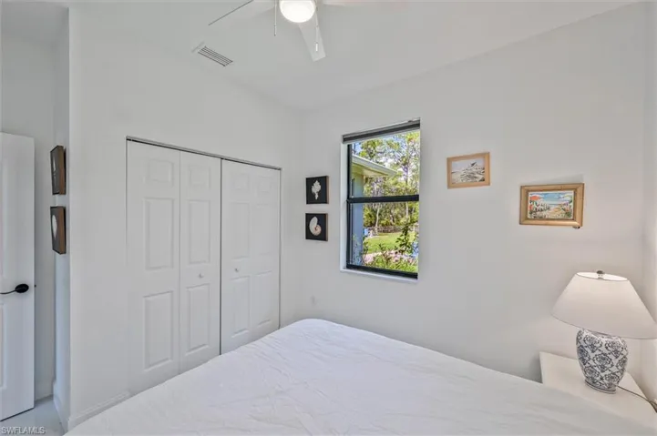 Bright interior featuring a window overlooking greenery, a ceiling fan, and bi-fold closet doors