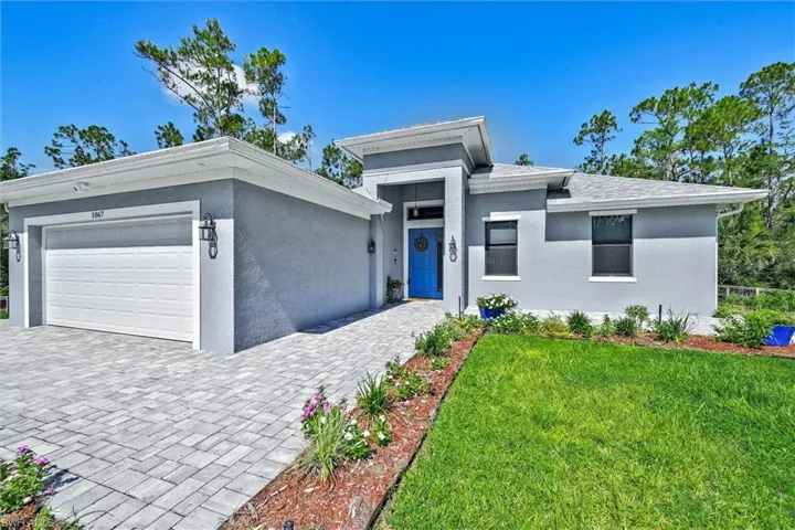 Contemporary stucco exterior with a prominent blue entry door