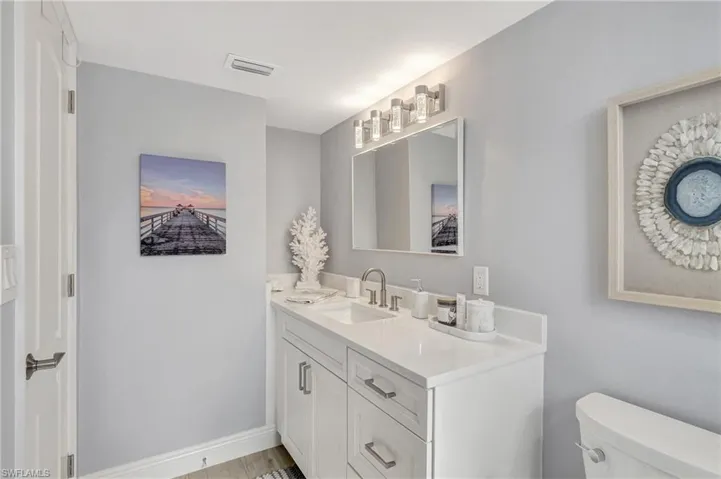 Bathroom with vanity, hardwood / wood-style flooring, and toilet