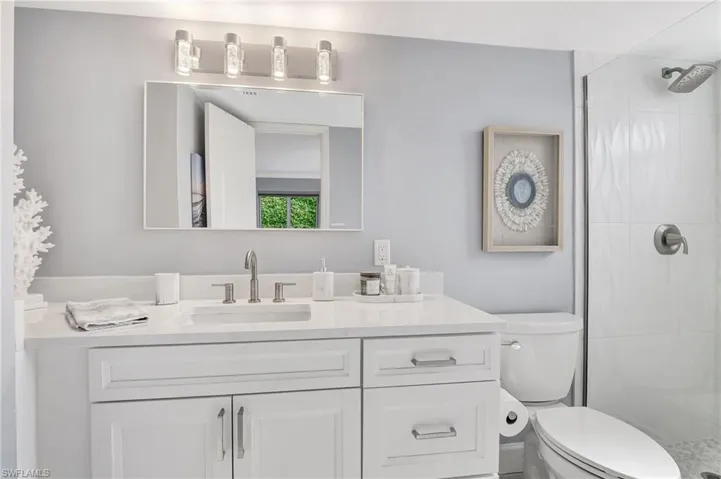Bathroom with vanity, toilet, and a tile shower