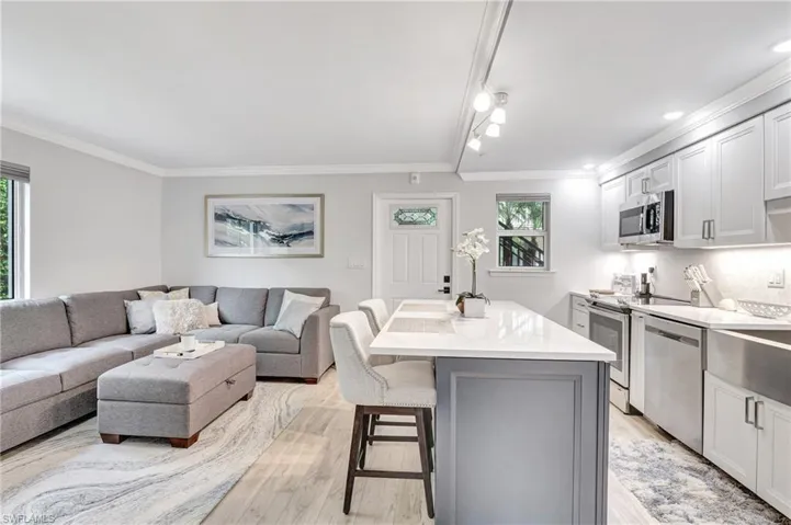 Kitchen with light hardwood / wood-style flooring, a kitchen bar,