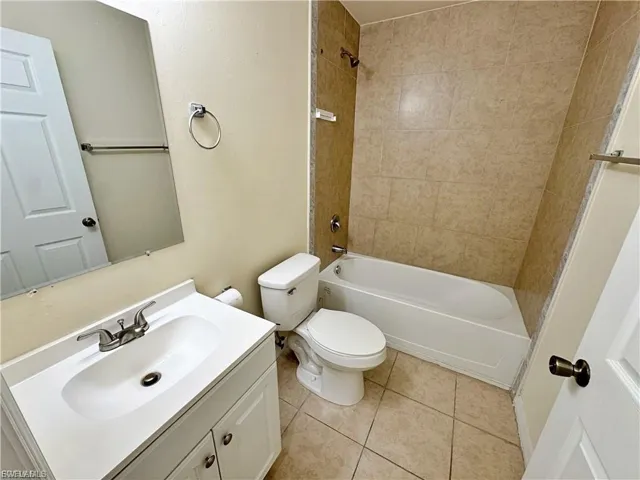 Full bathroom with vanity, light tile patterned floors, and bathtub / shower combination