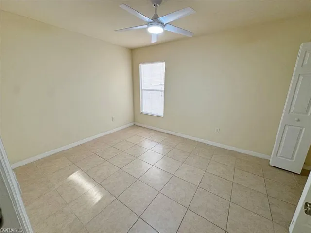 Unfurnished room with light tile patterned floors and a ceiling fan