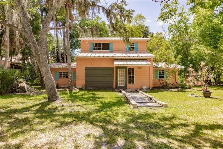 Rear view of guest house featuring a lawn