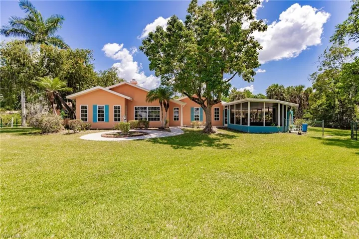 View of front facade with a sunroom and a front lawn