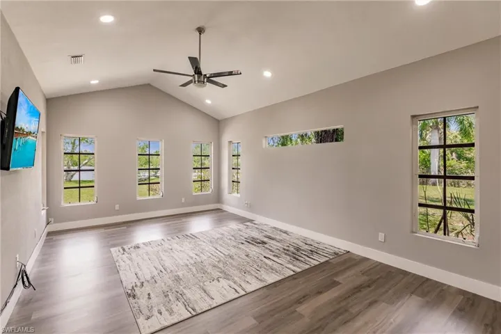 Main Bedroom  featuring light LVT  wood-type flooring, lofted ceiling, and ceiling fan