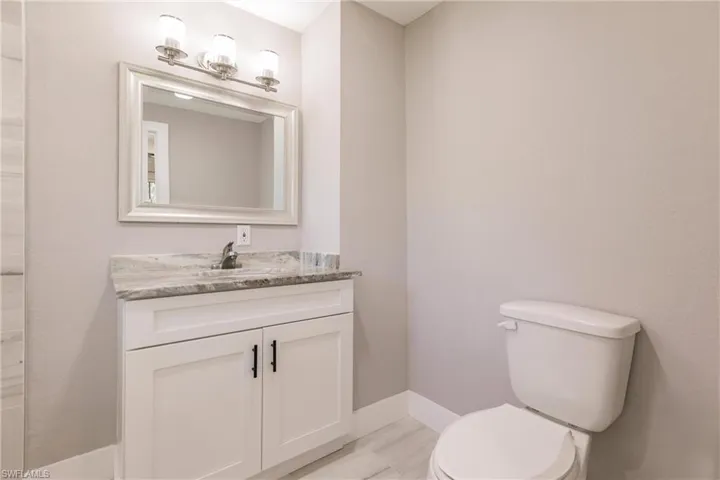 Bathroom featuring large vanity and toilet