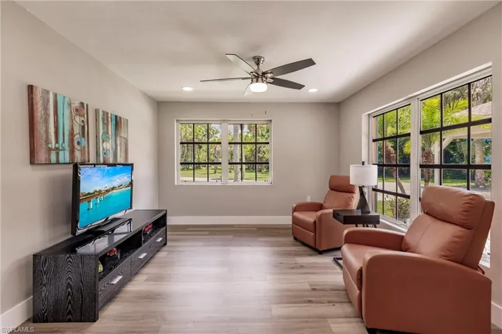 Living room with LVT/ wood-style flooring, plenty of natural light, and ceiling fan