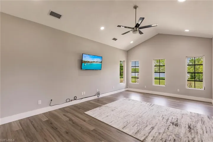 Master bedroom with high vaulted ceiling,  LVT / wood-style flooring, and ceiling fan