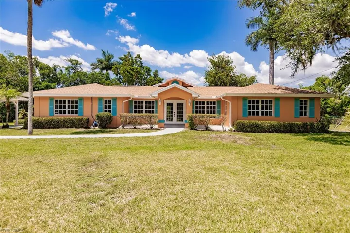 Single story home with french doors and a front lawn