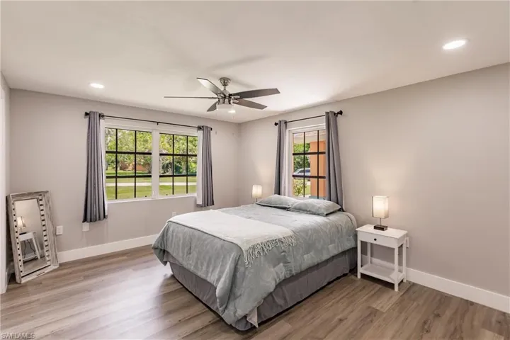 Bedroom with ceiling fan, multiple windows, and LVT / wood-style floors