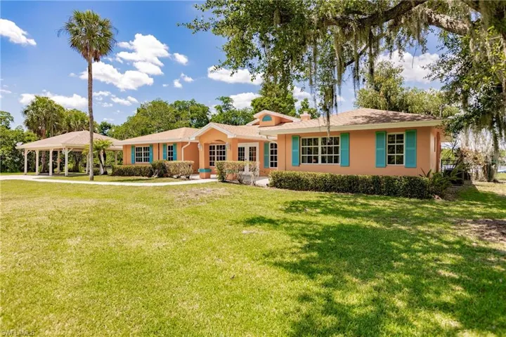 Ranch-style home featuring a 3 carport and a front lawn