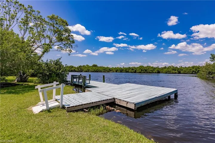 View of dock featuring a water view and a yard