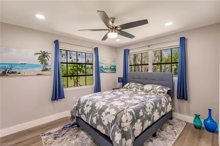 Bedroom with ceiling fan and LTV / wood-style floors